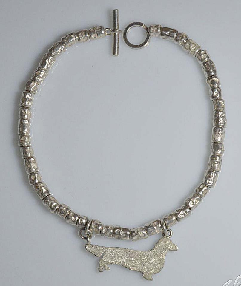 Bracciale a intercalari in argento, con sagoma pendente picchiettata di un Bassotto